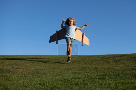 Foto de Un niño sueña con convertirse en piloto de cohetes. Concepto de imaginación y motivación. Feliz niño saltando y corriendo con avión de juguete contra fondo azul cielo de verano - Imagen libre de derechos