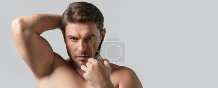 Téléchargez les photos : Blanc bel homme confiant essayant de faire une coupe de cheveux par lui-même avec des ciseaux. Une coupe masculine. Ciseaux de coiffeur, salon de coiffure. Ciseaux de coiffeur. Bannière pour en-tête, espace de copie. Affiche pour web design - en image libre de droit