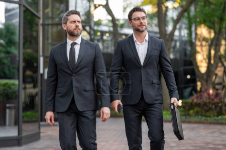 Photo for Business men walking across the street on american city outdoor. Business successful. Businessmen were motivated to succeed - Royalty Free Image