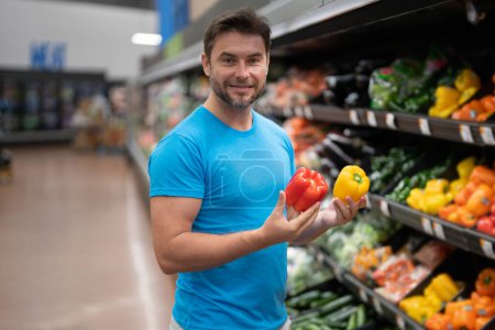 Téléchargez les photos : Homme aux fruits et légumes à l'épicerie. Aliments sains pour la santé masculine. Homme avec panier plein de légumes frais. Homme à l'épicerie ou au supermarché - en image libre de droit