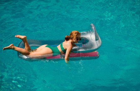 Téléchargez les photos : Femme en maillot de bain en vacances d'été. Piscine pour filles. Dame d'été sur matelas gonflable - en image libre de droit