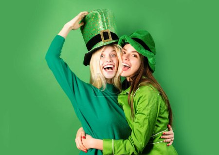 Téléchargez les photos : St Patricks Day. Deux filles en perruque et une casquette dans un bar. Un concept de fête. S'amuser - en image libre de droit