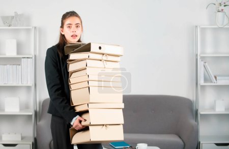Busy young businesswoman, frustration secretary girl working overtime. Stressed young businesswoman with folders of documents. Job, occupation and overworking concept