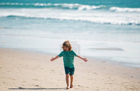 Foto de Niño caminar a la playa del mar, las manos levantadas. Sorprendido niños sorprendidos emociones - Imagen libre de derechos