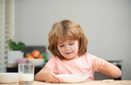 Téléchargez les photos : Enfant mangeant des aliments sains. Mignon petit garçon manger de la soupe pour le déjeuner - en image libre de droit