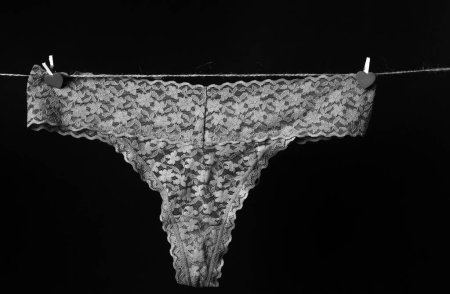 Foto de Thong bikini panties, beige lace underwear lingerie on black - Imagen libre de derechos