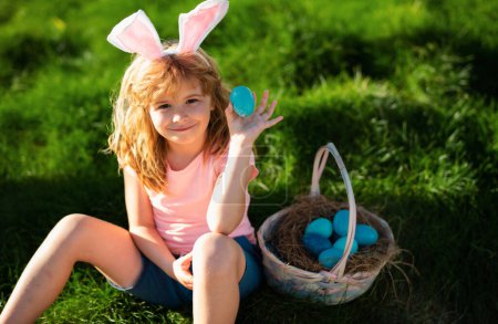 Téléchargez les photos : Chasse aux œufs de Pâques. Joyeux Pâques. Enfants dans les oreilles de lapin avec oeuf de Pâques dans le panier. Garçon jouer dans la chasse oeufs - en image libre de droit