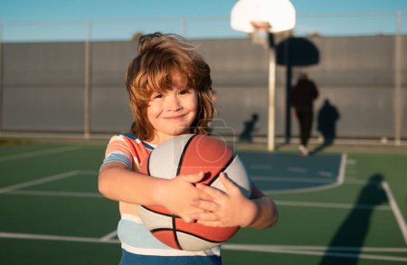 Photo for Happy little boy kid playing basketball on playground - Royalty Free Image