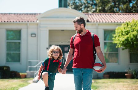 Téléchargez les photos : Père et fils marchant dans le parc de l'école. Début des leçons - en image libre de droit