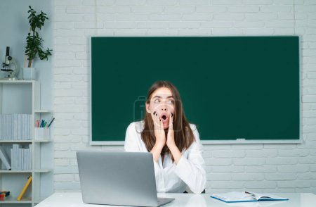 Photo for Portrait of a surprised female student studying in school classroom - Royalty Free Image