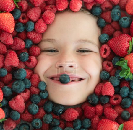 Photo for Berries child face close up. Top view photo of child face with berri. Berry set near kids face. Cute little boy eats berries. Kid eating vitamins. Close up kids face - Royalty Free Image