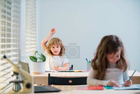 Photo for Education, learning and people concept. Little student girl with book writing school test. Back to school. Happy cute child is sitting at a desk indoors - Royalty Free Image