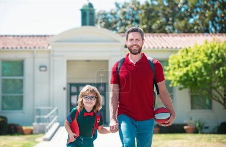 Photo for Outdoor school. Father and son come back from school. School, family, education and outdoor concept - Royalty Free Image
