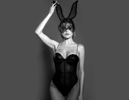 Femme sexy avec des oreilles de lapin. Dame sensuelle posant dans une belle robe et un masque de lapin noir