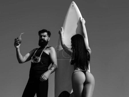 Photo for Summertime couple vacation. Sexy woman in bikini. Summer concept. Sexy man in swimsuit. Surfboard - Royalty Free Image