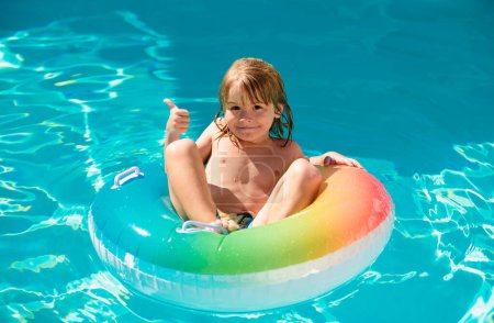 Téléchargez les photos : Enfants jouant dans la piscine avec anneau flottant - en image libre de droit