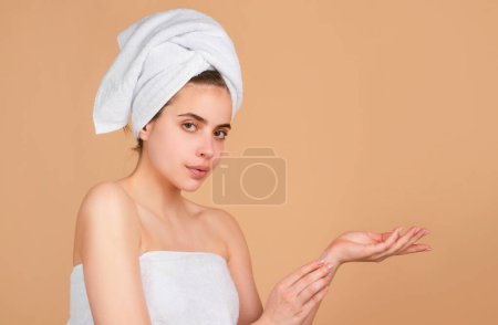 Téléchargez les photos : Belle fille avec une serviette sur la tête, Concept de produits cosmétiques, soins du visage, cosmétologie, beauté et spa - en image libre de droit