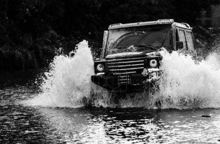 Jeep Abenteuer im Freien. Safari-Geländewagen Mudding ist ein Geländewagen, der durch ein Gebiet aus nassem Schlamm oder Lehm fährt. Geländewagen geht auf Bergstraße. Spuren auf einem matschigen Feld