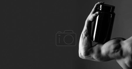 Photo for Taking vitamins for a healthy diet. Muscular man with vitamin supplements. Strong man hold supplement bottle. Bodybuilding sport and fitness. Vitamin diet and sport nutrition. Sport diet. - Royalty Free Image