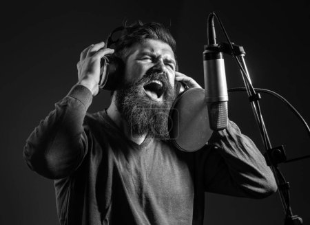 Cantante en un estudio de grabación. Expresivo hombre barbudo con micrófono. Cara de expresión de cerca. Karaoke signer, vocalista musical