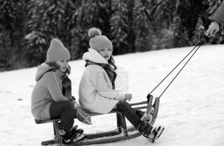 Photo for Children on sleigh. Kids boy and girl plays outside in the snow. Winter, holiday and Christmas time. Family christmas holiday outdoor - Royalty Free Image