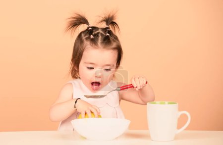 Photo for Cute baby child eat food, babies eating. Little baby eating fruit puree - Royalty Free Image