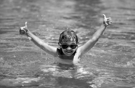 Téléchargez les photos : Enfant excité se détendre dans la piscine d'été. Les enfants jouent dans une station tropicale. Vacances familiales à la plage - en image libre de droit