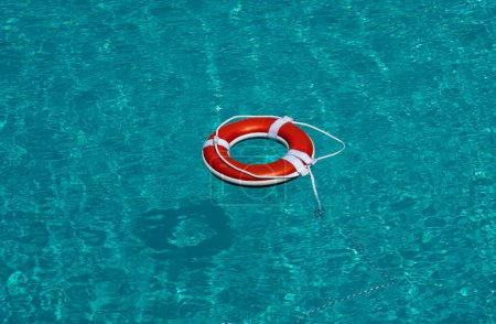Photo for Life buoy in blue swimming pool. Lifebuoy pool ring float on blue water - Royalty Free Image