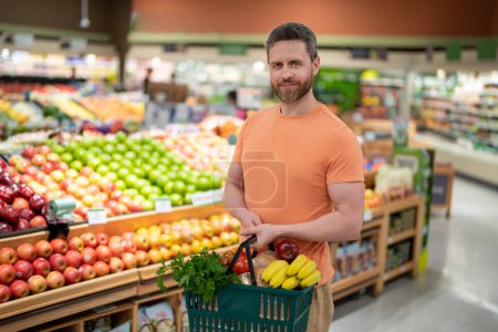 Téléchargez les photos : Homme aux fruits et légumes à l'épicerie. Aliments sains pour la santé masculine. Homme avec panier plein de légumes frais. Homme à l'épicerie ou au supermarché - en image libre de droit