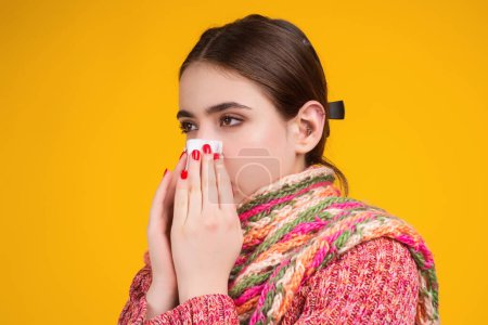Blow the snot. Woman in sweater and scarf hold napkin blow snot isolated on yellow. Mucus flowing from nose. Girl with snot, runny nose. Suffers from allergy. Nose allergy, flu sneezing nose. Allergy