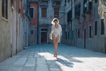 Foto de Hermosa mujer posando sexy al aire libre durante un tiroteo de moda. Jovencita parada afuera en la ciudad europea italiana. Ropa de moda en una chica, estilo sexy - Imagen libre de derechos