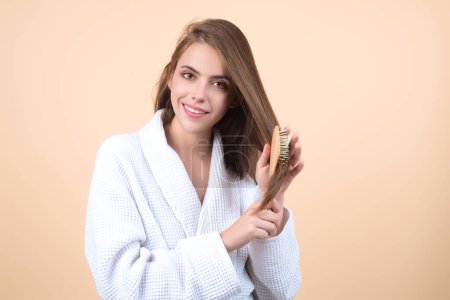 Photo for Young woman combing hair. Beautiful woman brush healthy hairs. Hairstyle and haircare concept. Girl combing and brushing hair in studio. Woman with comb combing hair. Hair brush - Royalty Free Image