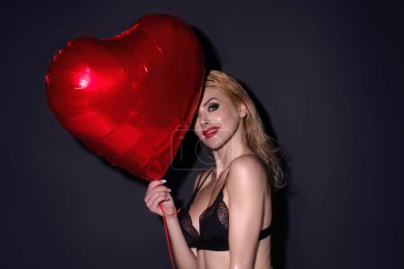 Photo for Woman in love with heart. Beautiful young woman holding red heart baloons, valentines day. Romance date. Woman celebrating Valentines Day. Portrait pretty woman with balloon heart shape - Royalty Free Image