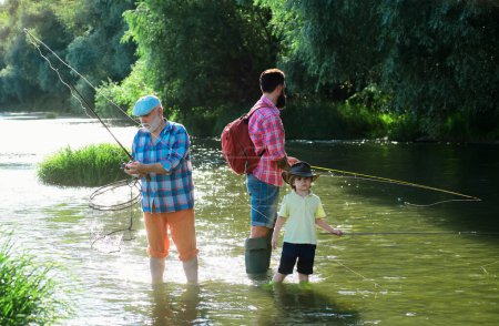 I love fishing. Senior man fishing with son and grandson. Grandfather, father and son are fly fishing on river
