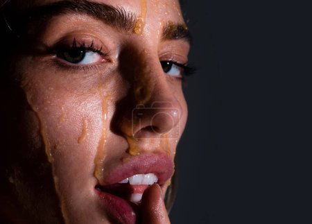 Beautiful young woman with honey on her face. Close up portrait of girl with a honey facialmask closeup. Beautiful woman with honey on her face. Healthy perfect skin. Honey treatment