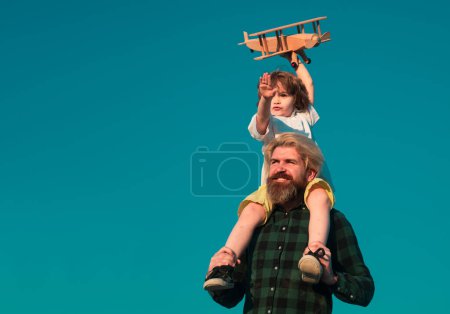 Téléchargez les photos : Petit garçon pilote. Père et fils jouant avec un avion en bois - en image libre de droit