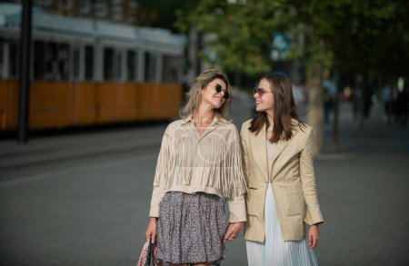 Photo for Two excited happy women walking together on the street. Happy fashionable girls in city. Young joyful women expressing positivity, vacation with cheerful emotions, great mood - Royalty Free Image