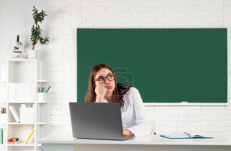 Photo for Female college student working on a laptop in classroom, preparing for an exam. Online learning at school, distance education - Royalty Free Image