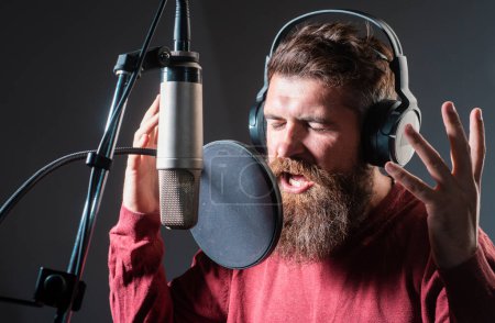 Téléchargez les photos : Chanteur chantant une chanson d'enregistrement rock dans un studio de musique. Karaoké excité - en image libre de droit