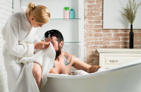 Téléchargez les photos : Couple dans le toilettage de bain. Soins de la peau à la maison salle de bain. Homme et femme sensuelle. Soins de la peau. Homme musclé dans le bain. La vie quotidienne. Douche personne à la maison style de vie - en image libre de droit