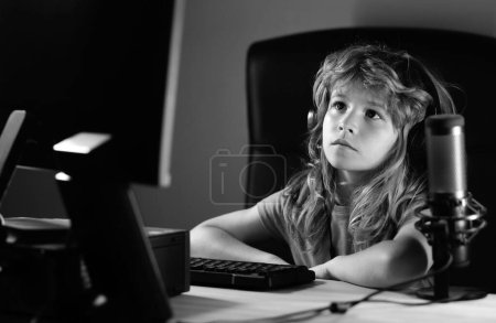 Photo for Little child gamer play computer game on desktop. Gaming stream and blogging for kids. A pretty child learns a lesson using a desktop computer at home. Home education - Royalty Free Image