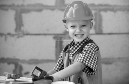 Photo for Child in building helmet, hard hat. Repair home. Child dressed as a workman builder. Portrait little builder in hardhats. Little builder in helmet - Royalty Free Image