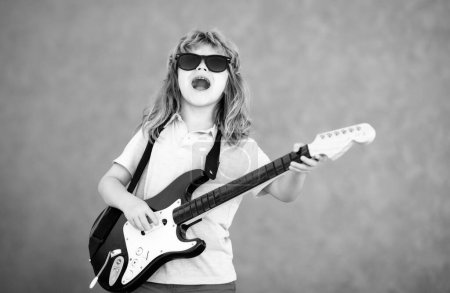 Foto de Funny boy hipster with guitar. Concept of kids music hobby - Imagen libre de derechos