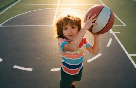 Photo for Kid playing basketball. Child boy preparing for basket ball shooting. Best sport for kids. Active kids lifestyle - Royalty Free Image