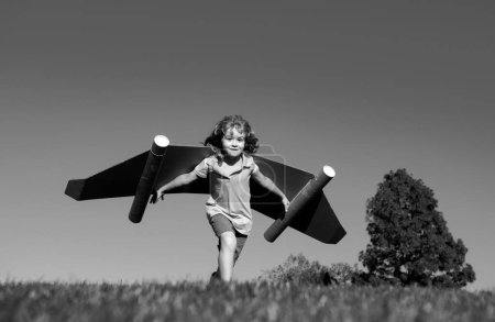 Photo for Boy child with wings at sky imagines a pilot and dreams of flying. Kids adventure, children freedom and imagination concept - Royalty Free Image