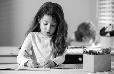Téléchargez les photos : Un élève dessine en classe à l'école - en image libre de droit
