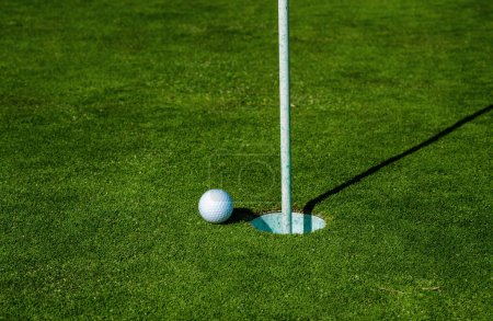 Photo for Golf ball on lip of cup on grass background. Golf hole. Golf ball on the lawn. Sport golf background with copy space - Royalty Free Image