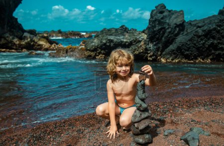 Téléchargez les photos : Les petits galets sont empilés sur une roche volcanique au bord de la mer. Concept zen - en image libre de droit
