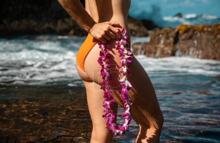 Téléchargez les photos : Beau corps féminin sur la plage, les vacances et les voyages en vacances d'été. Hawaï femme avec guirlande de fleurs lei d'orchidées roses en bikini sur la plage de l'île hawaïenne - en image libre de droit