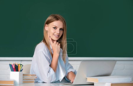 Téléchargez les photos : Étudiante travaillant sur un ordinateur portable en classe, se préparant à un examen. Portrait de joyeux étudiant universitaire regardant la caméra - en image libre de droit